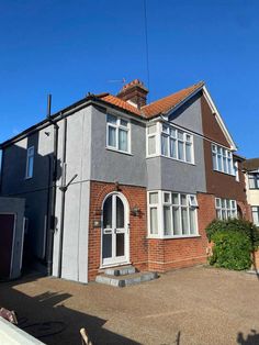 a grey house with red brick and white trim