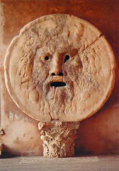 an ancient sculpture with a face on it