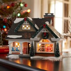 a small house with christmas decorations on the windowsill