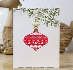 a christmas ornament hanging from a tree branch on top of a wooden table