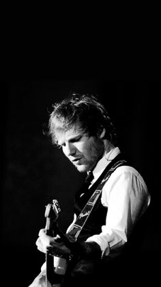 black and white photograph of a man playing an electric guitar