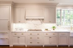 a kitchen with marble counter tops and white cabinets