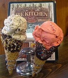 three ice cream cones sitting on top of a wooden table