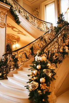 a staircase decorated for christmas with ornaments and garland on the bannister railings