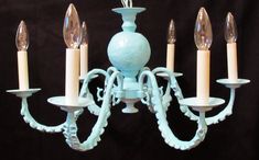 a blue chandelier with five candles hanging from it's center and four arms