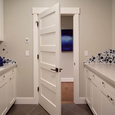 an empty kitchen with white cabinets and blue towels on the counter tops, along with a washer and dryer