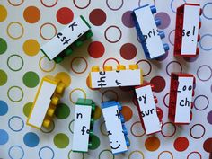 four lego blocks with words on them sitting on a polka dot tablecloth covered surface