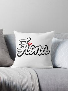 a pillow with the word fiore on it sitting on a couch next to pillows