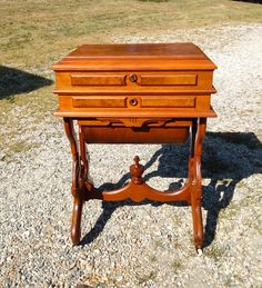 an old wooden desk sitting on top of gravel