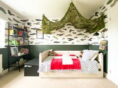 a child's bedroom with camouflage wallpaper and bedding