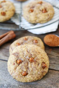 three cookies on a wooden table with cinnamon sticks