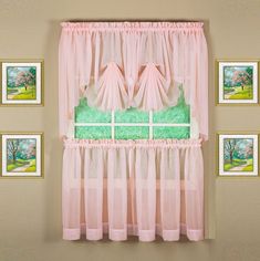 a window with pink curtains and pictures on the wall