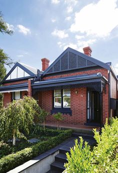 a red brick house surrounded by greenery and trees