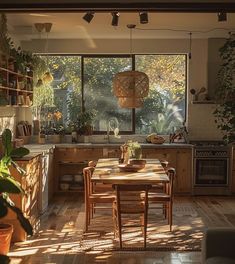 an open kitchen and dining room area with wooden flooring, potted plants on the table