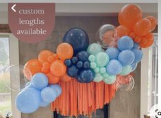 balloons and streamers are hanging from the ceiling in an orange, blue, and gray color scheme