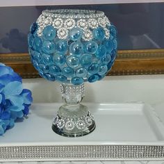 a blue vase sitting on top of a white tray with flowers in front of it