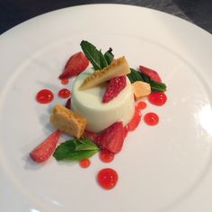 a white plate topped with dessert and fruit