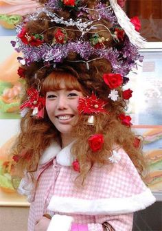 a woman with long red hair and flowers on her head is smiling at the camera