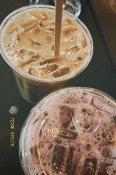 two plastic cups filled with liquid on top of a table