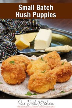 small batch hush puppies on a plate with butter and parmesan cheese in the background