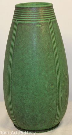 a green vase sitting on top of a white table