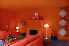 an orange living room with modern furniture and decor