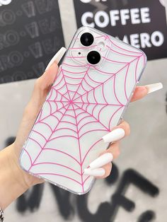 a person holding up a phone case with a spider web design on it