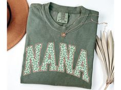 Nana Christmas Shirt, Cute Nana Holiday Shirt, Xmas Day Shirt for Nana, Shirt for Nana, Grandma Tshirt, First Christmas as a Nana, Nana Gift - Direct to garment printed on Comfort Colors 1717 Crewneck T-shirts - Shirt sizes are unisex, please refer to sizing chart in listing photos - 100% combed and ring-spun cotton (fiber content may vary for different colors) CARE Machine wash cold (not exceeding 90 F) inside out Hang dry highly recommended, tumble dry low inside out if desired Do not iron on Nana Gifts, Color Care, Holiday Shirts, First Christmas, Christmas Shirts, Comfort Colors, Adult Outfits, Tops & Tees, Top Outfits