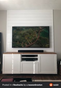 a flat screen tv mounted to the side of a white wall in a living room