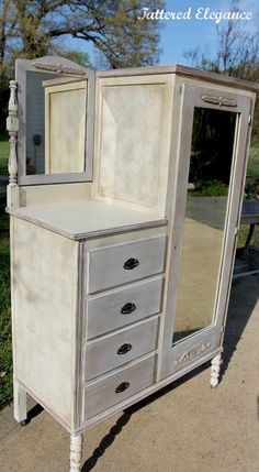 an old dresser has been painted white and is sitting on the side of the road