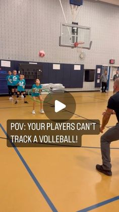 a man is playing with a ball in a gym while other people watch from the sidelines