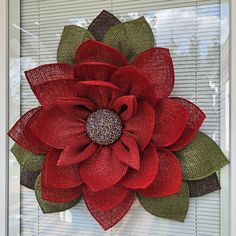 a red flower is hanging on the side of a window