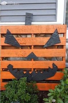 a wooden pallet decorated with metal pumpkins and jack - o - lantern faces