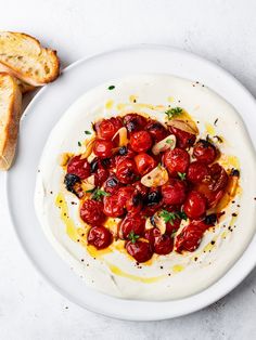 a white plate topped with tomatoes and bread