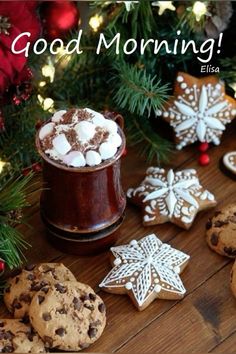 cookies, hot chocolate and marshmallows on a wooden table with the words good morning