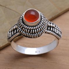 Designed by Rosalia Tarigan this ring exalts the radiance of natural carnelian. The red-orange gemstone finds a setting in silver with decorative Balinese granule work and sterling ropes. Luxury Elegant Men's Carnelian Ring, Carnelian Ring, Single Stone, Balinese, Cocktail Ring, Cocktail Rings, Gemstone Rings, Premium Quality, Jewelry Rings