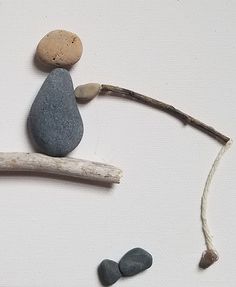 some rocks sitting on top of a branch and one has a rock in the shape of a man