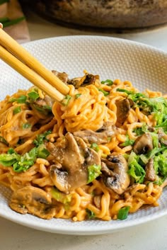 noodles with mushrooms and broccoli in a white bowl