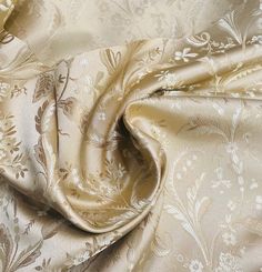 a close up view of the fabric with flowers and leaves in gold, white or beige colors