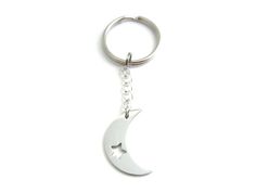 a metal keychain with a crescent and star on the front, hanging from a chain