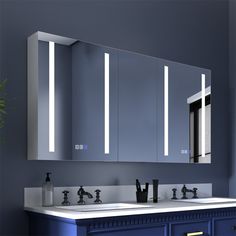 a bathroom vanity with two sinks and three mirrors on the wall next to each other