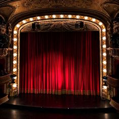 an empty stage with red curtains and lights