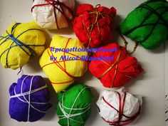 several balls of yarn wrapped in twine and tied together with string on white surface