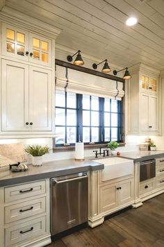 a large kitchen with white cabinets and stainless steel dishwasher in the center island