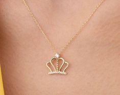 Our crown pendant necklace is 14k solid gold. Our crown pendant is decorated with zircon stones that look charming. When you consider it as a gift, it will make your loved ones happy on their birthday, mother's day, valentine's day, anniversaries, graduation, or women's day. It will be a perfect gift for your loved one that is the queen of your life. :) 🎁 If you want, you can add a gift note for your loved ones. It arrives in a special jewelry gift box. ✨ We respond to your questions happily. Y Crown Design Jewelry For Valentine's Day Gift, Valentine's Day Gift Jewelry With Crown Design, Valentine's Day Crown Design Jewelry Gift, Valentine's Day Elegant Crown Design Jewelry, Gold Birthday Jewelry With Crown Design, Gold Jewelry With Crown Design For Birthday, Elegant Diamond Jewelry For Birthday Gift, Gold Cubic Zirconia Necklace For Birthday, Diamond Necklace With Hallmark For Gift