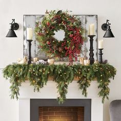 a christmas mantle with candles and wreath on it