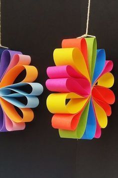 three colorful paper flowers hanging from strings