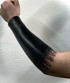 a man with his arm covered in black ink