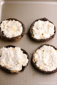 four cookies with cream cheese on them sitting on a cookie sheet