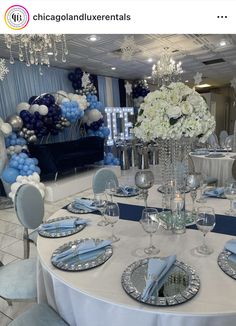 a table set up for a formal event with blue and white balloons in the background